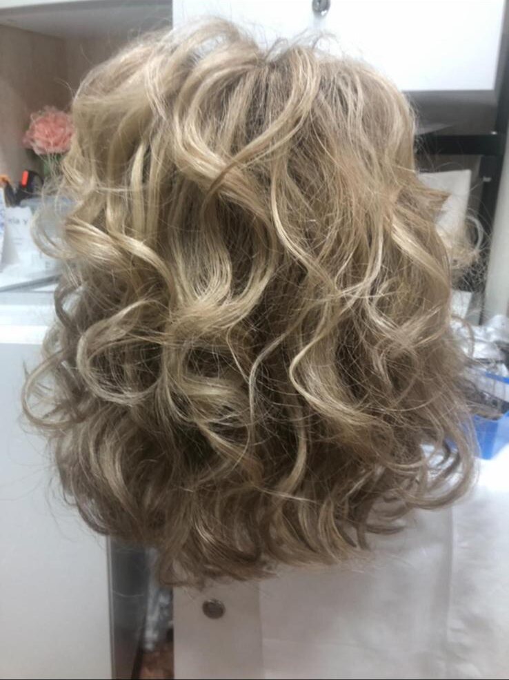 Peluca rubia con rizos definidos después del lavado y peinado en el salón