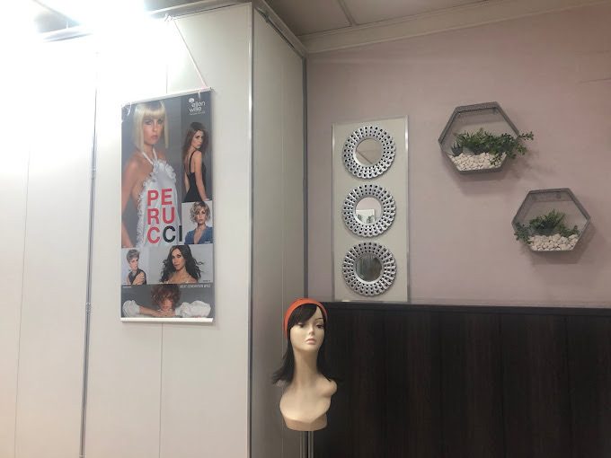 Rincón del salón con colección de pelucas Perucci